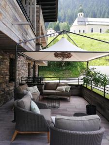 un patio con sofás, sillas y una sombrilla en Mountain See Lodge, en See