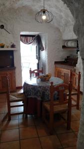 a kitchen with a table and chairs and a window at Casa Cueva Sierra Nevada - Monachil in Monachil