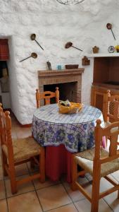 a dining room with a table and a fireplace at Casa Cueva Sierra Nevada - Monachil in Monachil