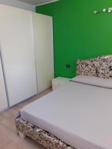 um quarto com uma cama branca e uma parede verde em Casa Dylan em Cagliari