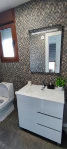 a bathroom with a sink and a toilet and a mirror at Excelente Dúplex de Lujo in Murcia +43 photos