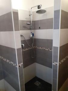 um chuveiro na casa de banho com azulejos castanhos e brancos em Casa Dylan em Cagliari