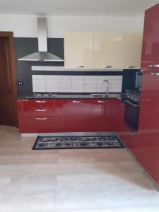 uma cozinha com armários vermelhos e um fogão em Casa Dylan em Cagliari