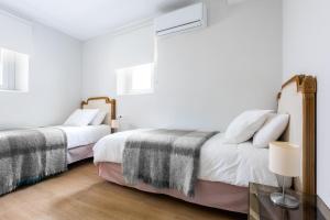 dos camas sentadas una al lado de la otra en un dormitorio en Plaza España, acogedor apartamento con patio by OUTIN, en Sevilla