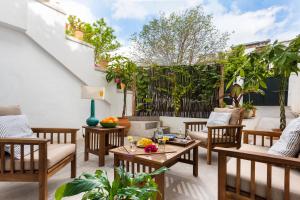 eine Terrasse mit Stühlen, Tischen und einem Zaun in der Unterkunft Plaza España, acogedor apartamento con patio by OUTIN in Sevilla