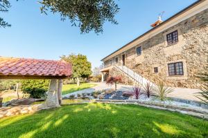 un bâtiment en pierre avec une cour avec un chemin en pierre dans l'établissement Casa do testado, à Ponte de Lima