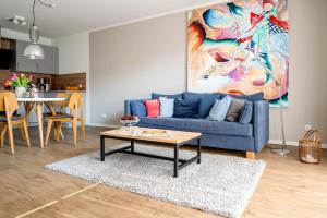 uma sala de estar com um sofá azul e uma mesa em Haus Lütt Schick Apartment Leenke em Büsum