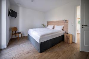 um quarto com uma cama grande e uma cadeira em Haus Lütt Schick Apartment Leenke em Büsum