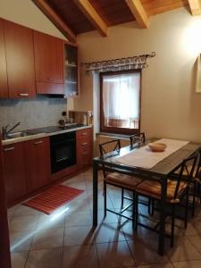 cocina con mesa, sillas y fregadero en Casa vacanze Ca' Manara, en Stazzona