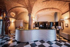 a bar in a large room with a tile floor at Settecento Hotel in Presezzo