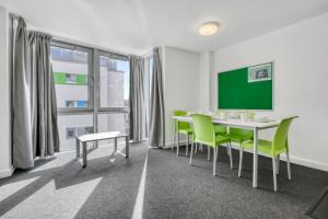 a room with a table and chairs and a greenboard at Central Single Room With Shared Kitchen in Luton in Luton