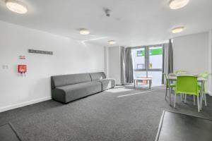 uma sala de estar com um sofá e uma mesa em Bright & Central Room in Luton, Sleeps 2 em Luton