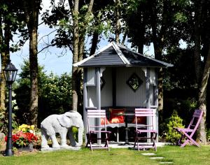 un elefante de juguete parado frente a una pequeña casa en Kilbawn Country House en Kilkenny