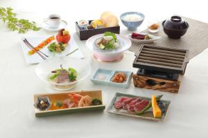 a table topped with plates of food and a grill at Hotel Binario Saga Arashiyama in Kyoto