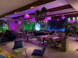 a restaurant with tables and chairs and purple lights at Borgo Antichi Orti Assisi in Assisi