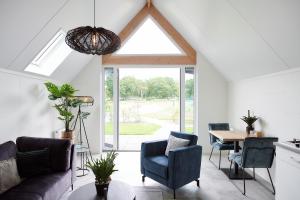 a living room with a couch and a table at Wellness Lodges x De IJsvogel in Voorthuizen