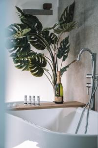 a bottle of wine sitting on a shelf above a bath tub at Wellness Lodges x De IJsvogel in Voorthuizen
