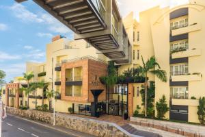 an apartment building on a street with palm trees at Calheta Beach - All-inclusive - Savoy Signature in Calheta