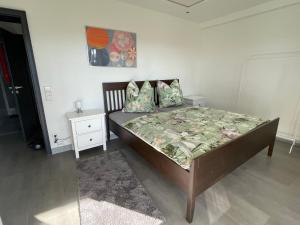 a bedroom with a bed and a night stand at Gartenapartment mit Ausblick stadtnah in Bad Mergentheim