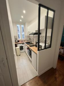 a kitchen with a sink and a stove top oven at Un appartement authentique à deux pas de Paris . in Saint-Mandé