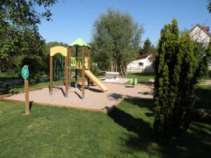 un parque infantil con un tobogán en un patio en Tente Familiale au Camping Hautoreille en Bannes