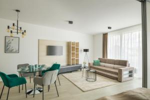 een woonkamer met een bank en een tafel en stoelen bij Parizs Garden Apartments in Debrecen