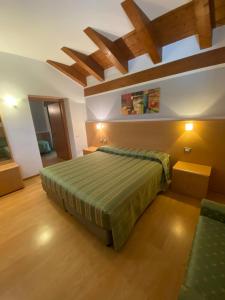 a bedroom with a bed in a room with wooden floors at Al Brenta in Levico Terme