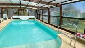 una piscina in una casa con finestre di Maison de charme piscine couverte chauffée a Mayrinhac-Lentour