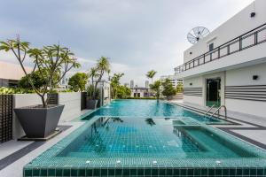 an infinity pool on the roof of a building with a house at D Varee Montara Thonglor 25 in Bangkok