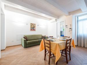 une salle à manger avec une table et un canapé vert dans l'établissement La Marina Apartment with Patio & Parking, à Fano
