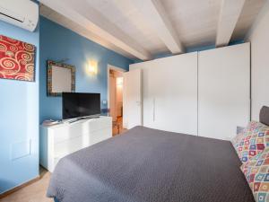a bedroom with a bed and a flat screen tv at La Marina Apartment with Patio & Parking in Fano
