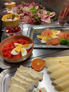 einen Tisch mit zwei Tabletts Essen mit Eiern und Käse in der Unterkunft Hotel zum Ritter Nidderau in Nidderau