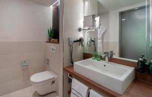 デュッセルドルフにあるメリア デュッセルドルフのバスルーム(洗面台、トイレ付)、電話が備わります。