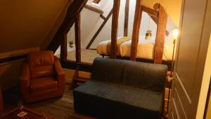 a living room with a chair and a stairway at Nuits au Grenier de Chartres in Chartres