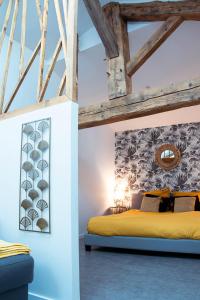 a bedroom with a yellow bed and wooden ceilings at Mon Cocon Bressan in Saint-Julien-sur-Reyssouze