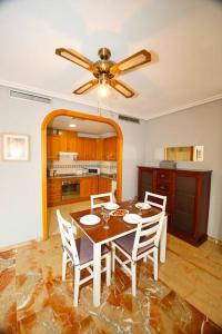 einen Esstisch mit Stühlen und einen Deckenventilator in der Unterkunft Castaños apartment with AC in Alicante