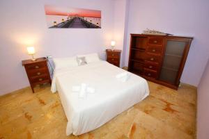 um quarto com uma cama branca e duas mesas de cabeceira em Castaños apartment with AC em Alicante