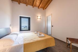 a bedroom with a large bed and a window at Ca Cia - Yellow Flat Gardone in Gardone Riviera