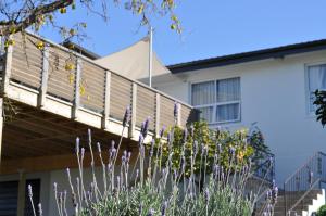 ein Haus mit einer Terrasse und Blumen davor in der Unterkunft 16 Havelock in New Plymouth