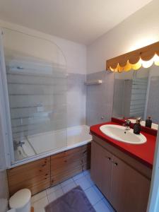 a bathroom with a sink and a tub and a toilet at Appartement T2 en résidence, centre ville d'Embrun in Embrun