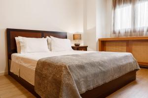 a bedroom with a large bed with white pillows at Melon Suites in Thessaloniki