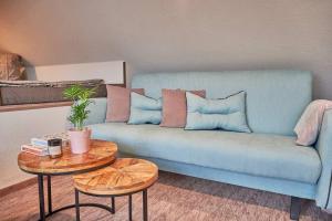 a blue couch in a living room with two tables at "Na Skale " Apartment in center, free parking in Bojnice