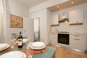 eine Küche mit einem Tisch mit Tellern und Weingläsern in der Unterkunft il giaggiolo apartment in Florenz