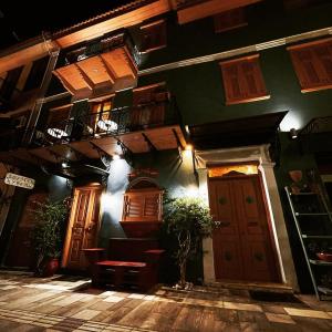 a green building with a balcony and a door at Kyveli Suites in Nafplio