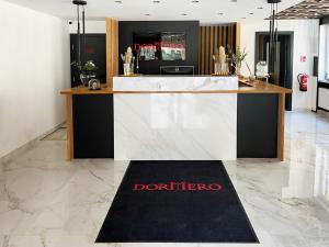 a bar in a lobby with a black and white counter at DORMERO Hotel Reutlingen in Reutlingen