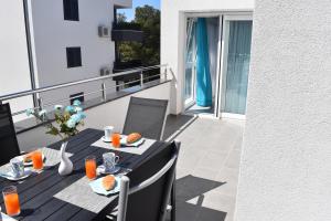 a table with food and orange juice on a balcony at Villa Dalija in Biograd na Moru
