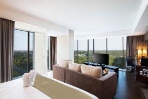 a living room with a couch and a television at Best Western Premier The Hive in Jakarta
