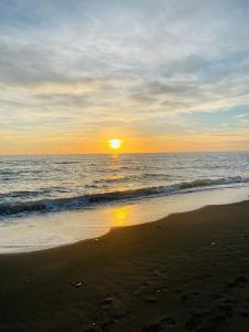 a sunset on a beach with the ocean at Dimora Novella in Lido di Ostia