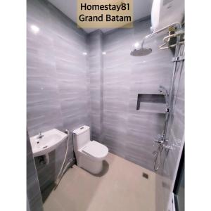 Homestay 81 Grand Batam في ناغويا: حمام به مرحاض أبيض ومغسلة