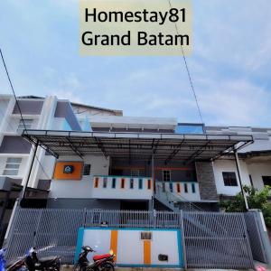 a building with two motorcycles parked in front of it at Homestay 81 Grand Batam in Nagoya
